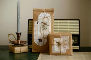 Beautifully wrapped vintage gifts next to an antique radio and candle for a cozy ambiance.